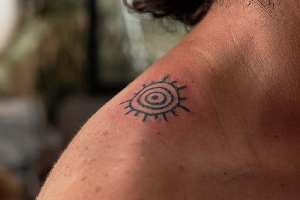 Frisch gestochenes Tattoo auf der Schulter – einfaches Design mit möglichen Reizungen durch ungeeignete Farbe